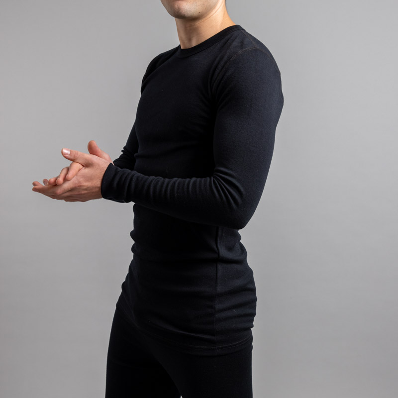 Front side view of a male wearing black Merino Skins – Unisex Long Sleeve Crew Neck