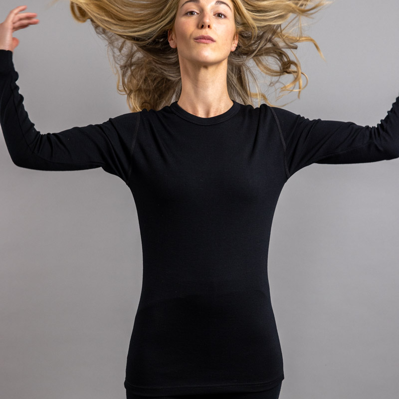 Front view of a female wearing black Merino Skins – Unisex Long Sleeve Crew Neck